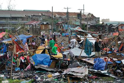 Residentes recuperan lo que queda de sus casas tras el paso del tifón Rai, en Cebu, en el centro de Filipinas, el 17 de diciembre de 2021. (AP Foto/Jay Labra)