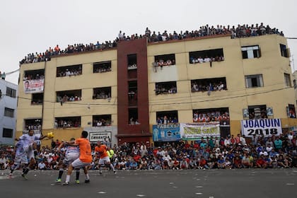 Residentes se agolpan en los balcones de un edificio para ver a los equipos de fútbol "La Pólvora" (Pólvora) y "Los chatarreros" (El Scrappers) jugar la semi-final de la Copa del Porvenir campeonato de fútbol callejero en Lima, Perú