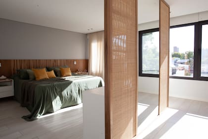 Respaldo de petiribí con una tira LED, mesas de noche flotantes y cómoda en madera laqueada de blanco (todo de Muchnik y Wainstein). Ropa de cama, almohadas, almohadones, pie de cama y manta (Lote Propio).