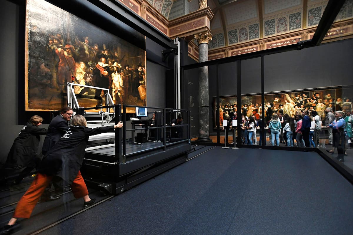 Restorers prepare Rembrandts famous painting the Night Watch, protected by a glass barrier and video surveillance, as it undergoes public restoration after a first phase of study, in Rijksmuseum in Amsterdam, Netherlands July 8, 2019. REUTERS/Piroschka van de Wouw