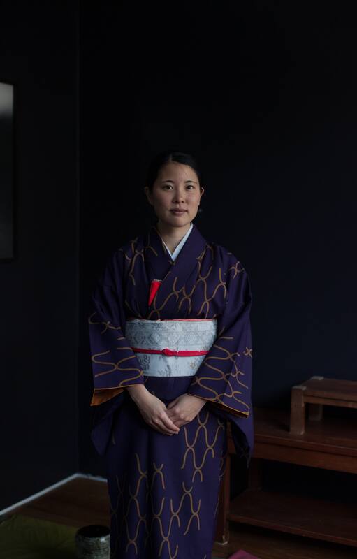Detalle de manos limpiando cuenco en una tradicional ceremonia del té japonesa.