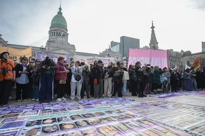 Retratos de víctimas de femicidio en la vereda, a las que se suman los de Agostina, Dulce, Noelia. 11° Marcha Ni Una Menos en el Congreso. 3J de 2026