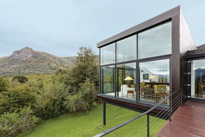 Revestimiento exterior de pino oregón con terminación en cetol oscuro. Deck de madera de pino con cetol semimate. Barandas en perfiles de hierro 'T'.