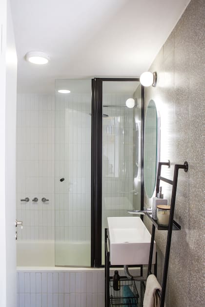Revestimiento granítico (Moltrasio), azulejos ‘Finlandia Soft’ (Acuarela) en la ducha y muebles livianos de hierro diseñados por el Estudio.