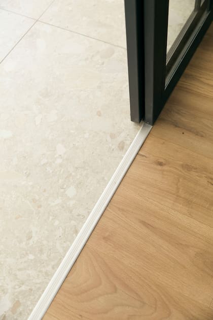 Revestimiento simil madera (BinylPro Historic Oak, Pisos Alemanes). Cerramiento (color Gris nocturno, Alba).
