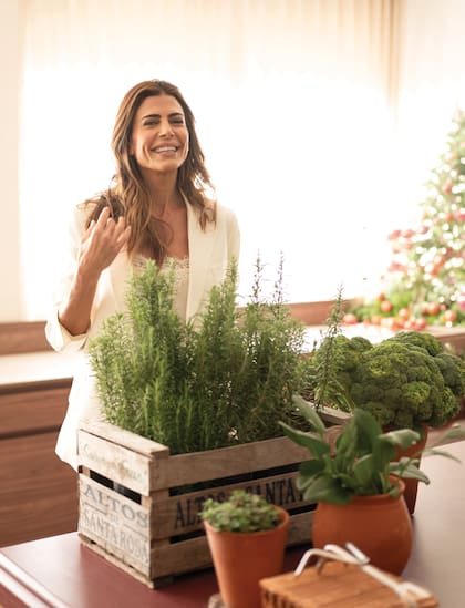 Espléndida, Juliana posa junto a las mesas de su evento, decoradas con tomates y brócolis naturales y piezas de cerámica de la Fundación Los Naranjos, creadas especialmente para esta propuesta