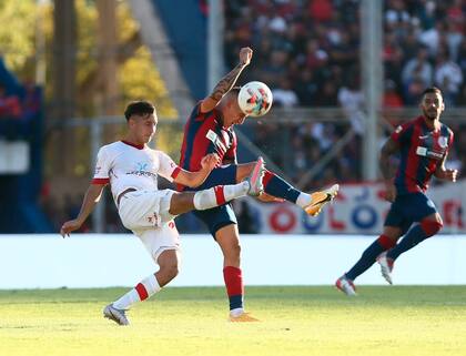 Ricardo Centurión se resguarda y evita el pelotazo de Santiago Hezze durante el clásico entre San Lorenzo y Huracán
