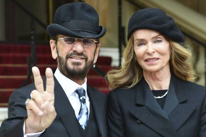 Ringo Starr y junto a su esposa, la actriz Barbara Bach, en las escalinatas del Palacio de Buckingham, tras ser distinguido por el príncipe Guillermo