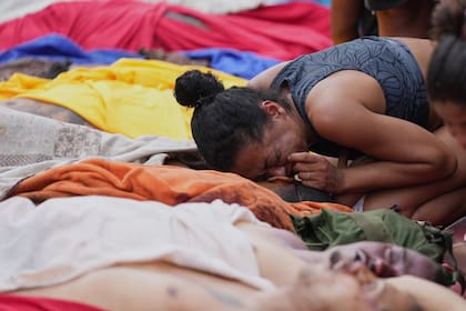 Río de Janeiro: trasladan los cuerpos tras el operativo contra Comando Vermelho y comienzan a identificarlos. Una mujer llora junto a un muerto
(AP Photo/Silvia Izquierdo)