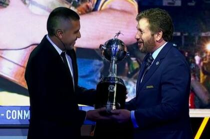 Riquelme recibe una réplica de la Copa Libertadores de manos de Domínguez, el presidente de Conmebol