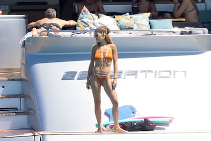 Rita Ora en un sensacional bikini naranja que combinó con un pañuelo estampado en la cabeza, collares al tono y cadenas en su cintura