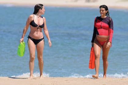 Rivero camina por la playa acompañada por una amiga.