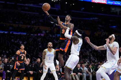 RJ Barrett (9), de los Knicks de Nueva York, ataca el aro sobre Dennis Schroder (17), de los Lakers de Los Ángeles, durante la segunda mitad del juego de baloncesto de la NBA, el domingo 12 de marzo de 2023, en Los Ángeles. (AP Foto/Marcio Jose Sanchez)
