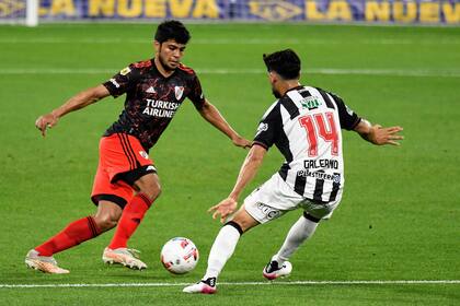 Robert Rojas, de River, sale con la pelota dominada ante la marca de Juan Galeano, de Central Córdoba.