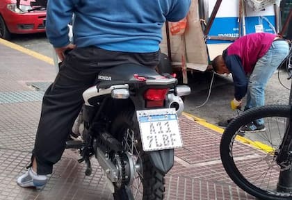 Roberto mira como el joven cartonero se pone sus zapatillas mientras él se queda en medias