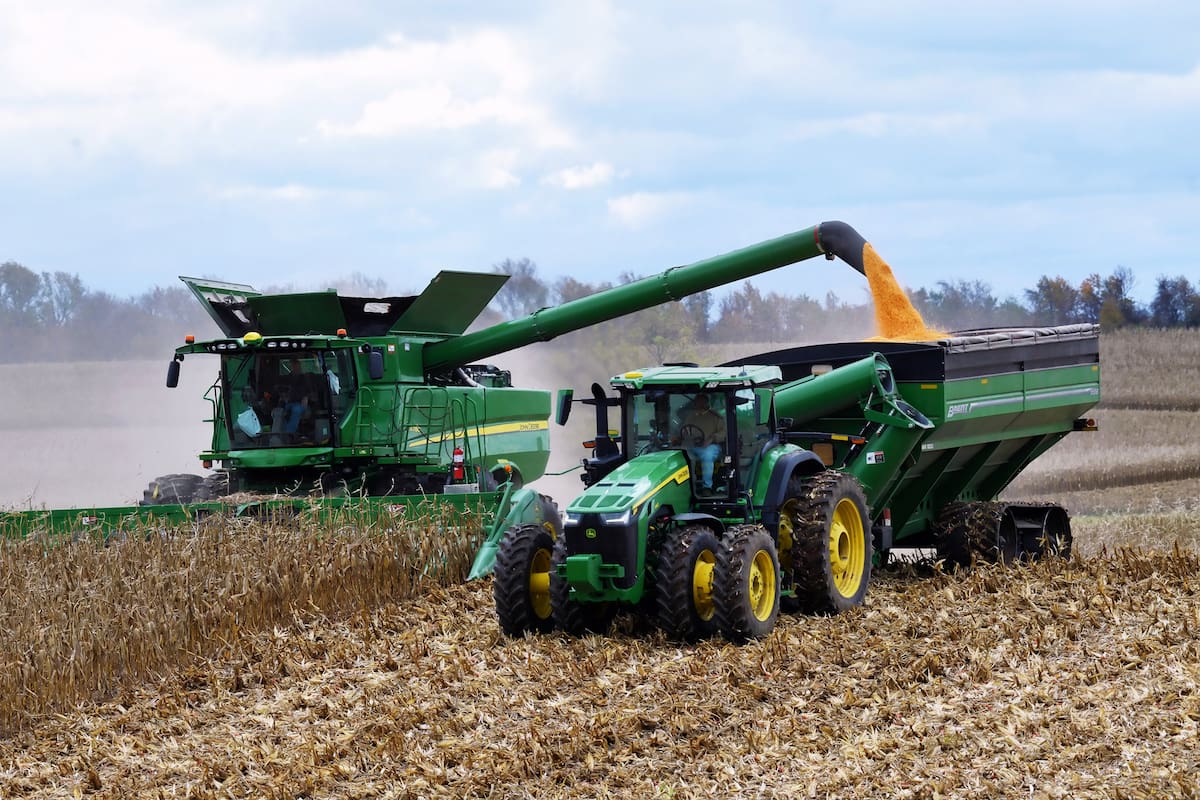 ROCKTON, ILLINOIS USA - OCTOBER 31, 2021: John Deer 8R340 tractor pulling a Brent 1196 grain cart while transfering corn from a John Deer S780 harvester