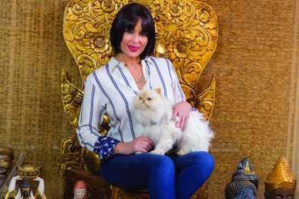 Rodeada por imágenes de Buda que coleccionó cuando practicaba yoga, posa con el gato que embalsamó, su primera mascota. Hoy, vive con cinco gatos en su piso de Retiro: Azabache, Garfield, Keila, Martita y Matutino.