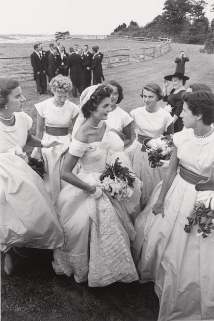 Rodeada por sus damas de honor, la flamante señora Kennedy conversa y muestra orgullosa su traje de novia.