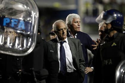 Rodolfo DOnofrio, entrenador del River Plate, centro, abandona el campo protegido por la policía antidisturbios después de que el partido contra Boca Juniors fue suspendido durante un partido de fútbol de la Copa Libertadores en Buenos Aires, Argentina