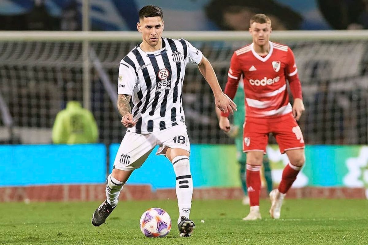 Rodrigo Villagra con la pelota al pie y la mirada adelante. Detrás suyo, Beltrán, en un duelo entre Talleres y River de 2023. El volante generó el pase más impactante del verano