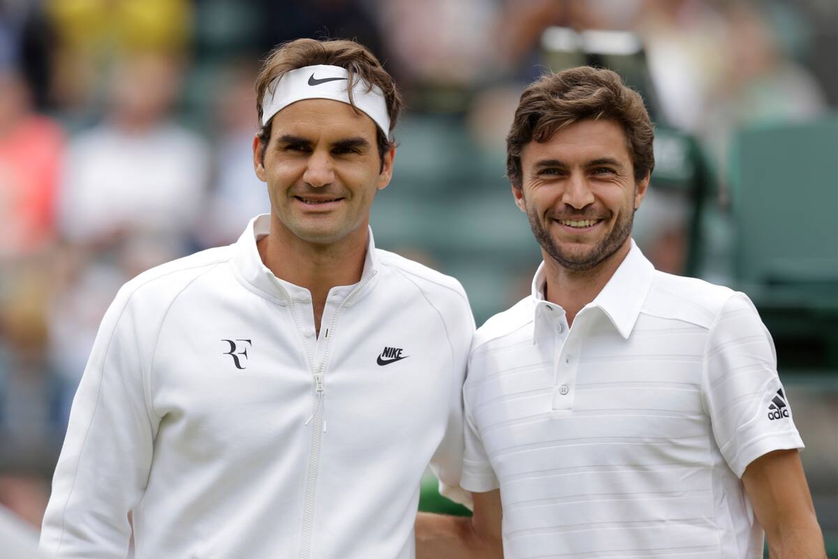 Roger Federer de Suiza, izquierda, y Gilles Simon de Francia posan para una fotografía antes del partido de cuartos de final individual masculino en el Campeonato de Tenis de Inglaterra sobre césped en Wimbledon, Londres, el miércoles 8 de julio de 2015.