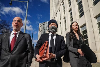 Roger Ng, al centro, un exbanquero de Goldman Sachs, sale de una corte federal acompañado de sus abogados Zach Intrater, izquierda, y Teny Geragos, derecha, tras recibir una sentencia de 10 años de prisión por su papel en el saqueo de un fondo de desarrollo de Malasia, el jueves 9 de marzo de 2023, en Nueva York. (AP Foto/Bebeto Matthews)