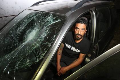 Rojas junto al Chevrolet Corsa con el cristal roto por la acción del taxista Rímolo