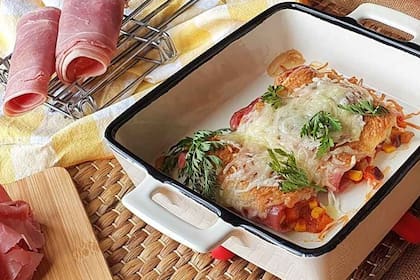 Rollos de jamón relleno de ricota y bañados en queso de rallar. Canelón sabroso y sin harina