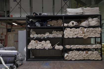 Rollos de tela y materiales utilizados para la confección de telones y fondos escenográficos. Algunas piezas alcanzan dimensiones monumentales y requieren semanas de trabajo antes de llegar al escenario.