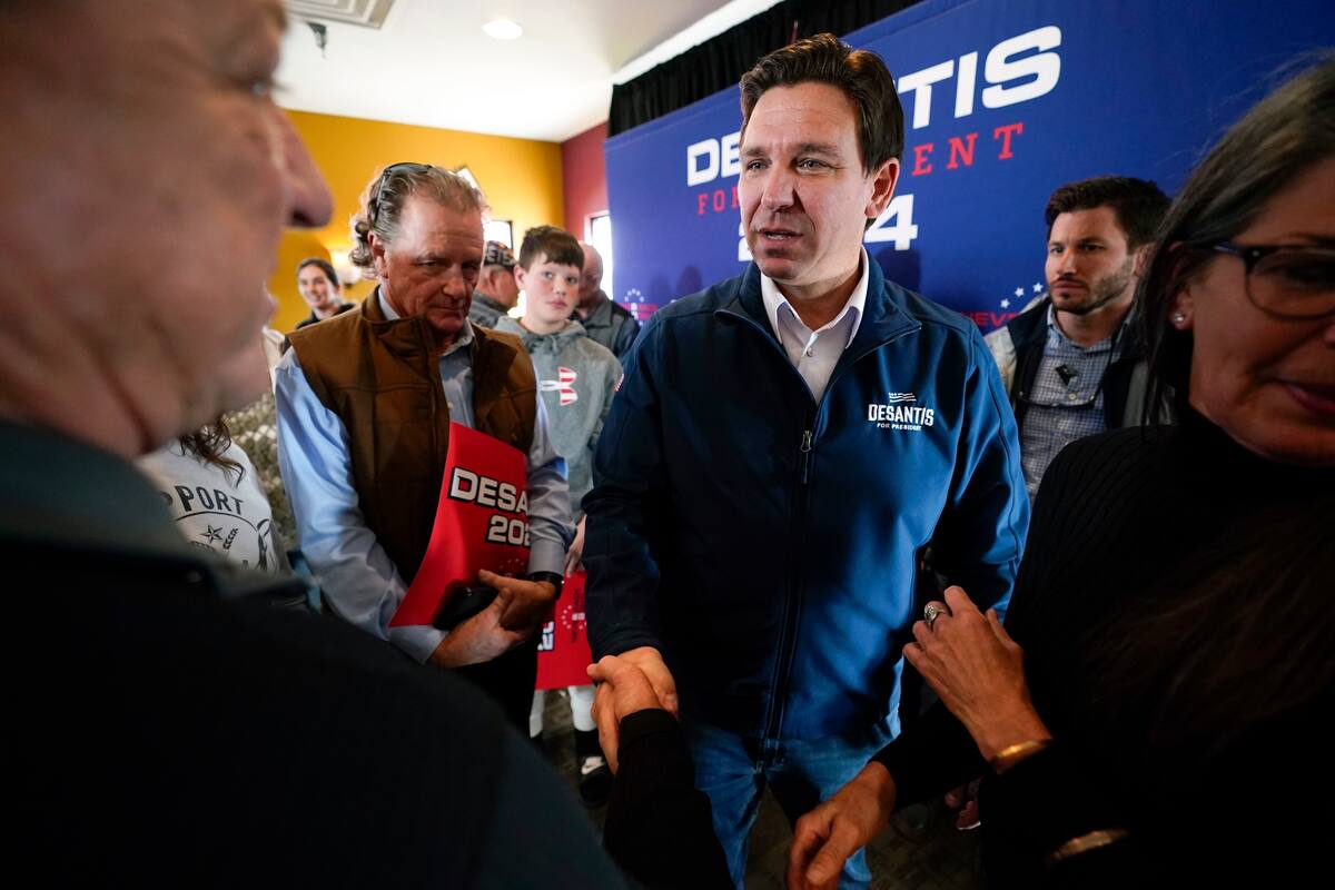 Ron DeSantis, gobernador de Florida y aspirante a la candidatura republicana para la presidencia, centro, conversa con partidarios en un acto de campaña, en noviembre de 2023, en Denison, Iowa. (AP Foto/Charlie Neibergall, archivo)