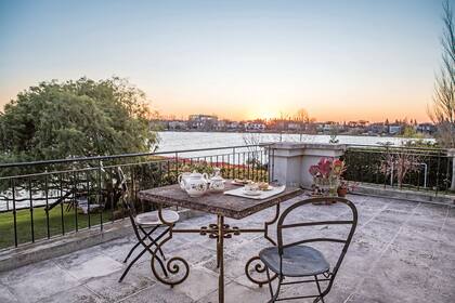 La terraza se disfruta a la hora del desayuno y al atardecer. Mesa con tapa de piedra y parte de la base de la mesa del comedor de la casa de la infancia de Alejandra. Las sillas Quilmes la acompañan desde su primer departamento de soltera. Catering (Lo de Loly).