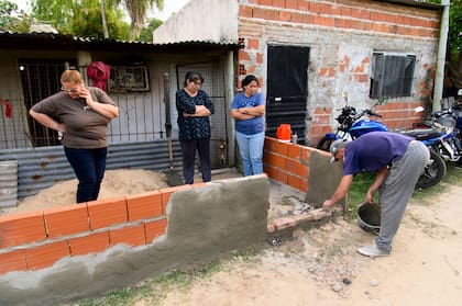 Roque Almirón levanta con su pareja un pequeño tapial que puede servir de barrera para amortiguar la crecida