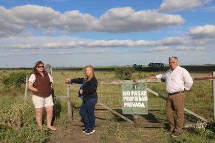 Rosana Valenzuela, Ana María y Gustavo Robles en la tranquera del campo de su propiedad