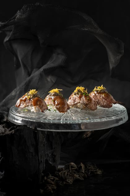 Rosu Nikkei: nigiris con salsa demi-glace nikkei, chimichurri de ajo, tartufo y alcaparras, completados con una terminación crocante de papa. Un cruce que también incorpora sabores de la cocina argentina.