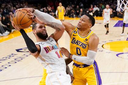 Russell Westbrook (derecha), de los Lakers de Los Ángeles, bloquea un tiro a canasta de Caleb Martin durante la primera mitad del juego de la NBA que enfrentó a su equipo con el Heat de Miami, el 4 de enero de 2023, en Los Ángeles. (AP Foto/Mark J. Terrill)