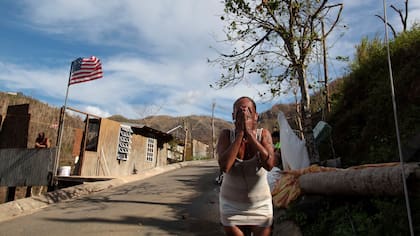 Ruth Santiago se refresca con agua de una tubería después de que el huracán María destruyó el puente de la ciudad en San Lorenzo