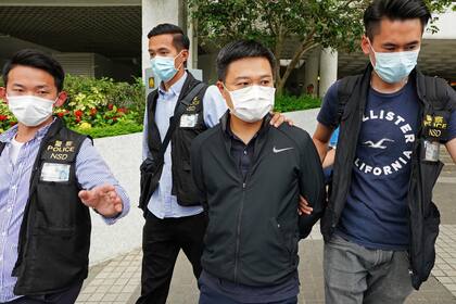 Ryan Law (segundo por la derecha), editor jefe del diario Apple Daily, es arrestado por agentes de la policía, en Hong Kong, el 17 de junio de 2021. (AP Foto)