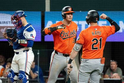Ryan O'Hearn, de los Orioles de Baltimore, a la izquierda, es felicitado por Austin Hays (21) después de conectar un jonrón solitario ante el lanzador relevista de los Rangers de Texas, José Leclerc, durante la novena entrada el sábado 20 de julio de 2024, en Arlington, Texas. (AP Foto/Jeffrey McWhorter)