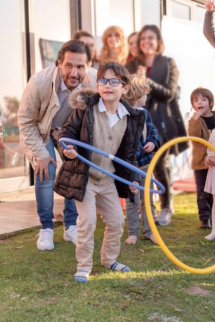 Sabrina contrató animadores para que entretuvieran a chicos y grandes.
En la foto, Germán se divierte con León en el juego de los aros.