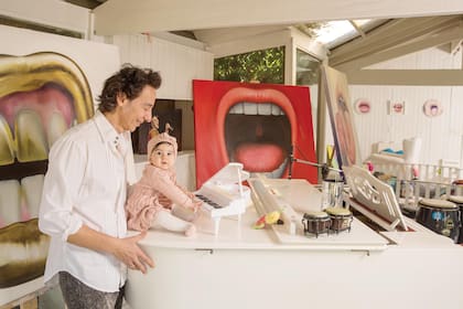 Sacha juega con un pequeño piano de cola igual al que tiene su papá. En esta sala de su casa, el cantante compuso su nuevo disco, "El regalo", en homenaje a su hija. Detrás de ellos pueden verse los cuadros pintados por Paola.