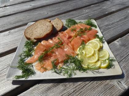 Salmón ahumado y curado por la empresa de Richard Irvine, con eneldo y rodajas de limón y pan integral