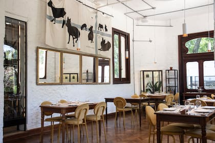 Salón de la planta baja, donde la impronta original convive con gestos contemporáneos, dando un aire cálido y relajado y con ventanas que enmarcan el verde.