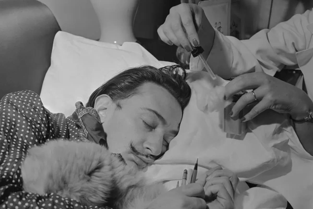 Salvador Dalí se acuesta en un sofá perfumado en su estudio con un puñado de lápices. Luego se le deja caer perfume en los párpados para influir en el carácter de sus sueños, porque los sueños son la materia de la que está hecho el surrealismo