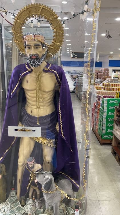 San Lázaro recibe dólares a cambio de protección a la entrada de un supermercado en el barrio sureño de Newburg en Louisville