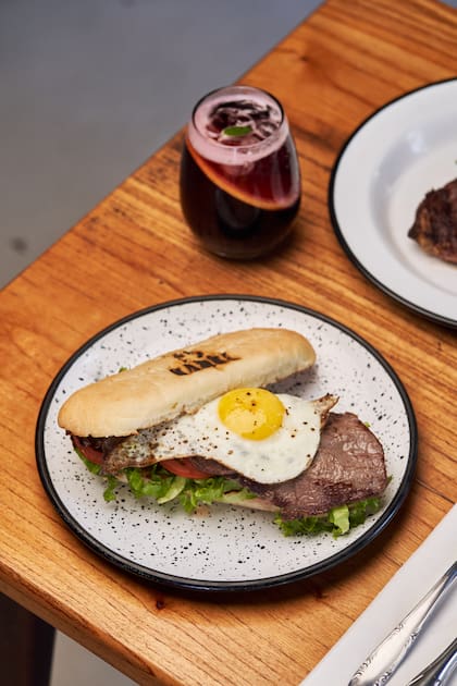 Sándwich de lomito con huevo, lechuga, tomate, morrón asado y alioli