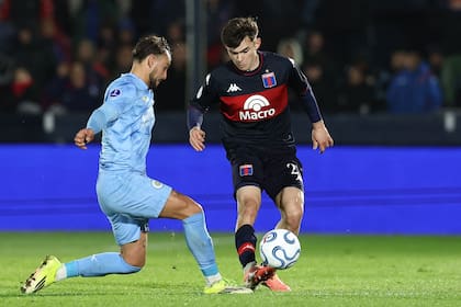 Santi López cubre la pelota ante Ezequiel Busquets