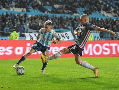 Santiago Ascacíbar intenta bloquear el ataque de Gastón Martirena; Racing le ganó a Estudiantes 2-1