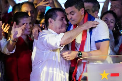 Santiago Peña, cuando era candidato del gobernante Partido Colorado, a la derecha, abraza al expresidente Horacio Cartes, su padrino político