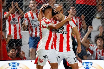 Santiago Rodríguez anotó el 2-0 de penal para Instituto y recibe el saludo de Rodrigo Pérez