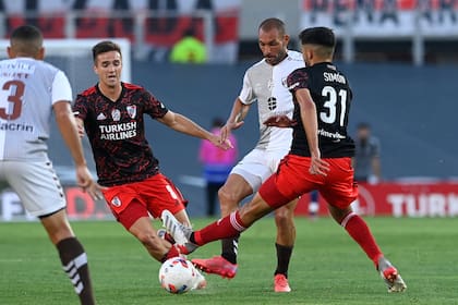 Santiago Simón disputa la pelota ante la atenta mirada de Agustín Palavecino